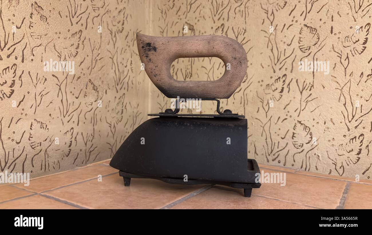 Gros plan du fer vintage de l'ère soviétique pour les vêtements. Appareil de cuisine en métal rétro original URSS polonais ustensiles de cuisine historiques. Poignée en bois - Image de stock capturée avec un smartphone