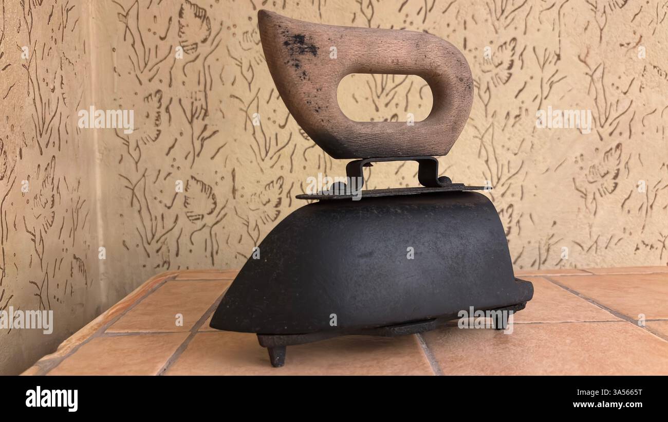 Gros plan du fer vintage de l'ère soviétique pour les vêtements. Appareil de cuisine en métal rétro original URSS polonais ustensiles de cuisine historiques. Poignée en bois - Image de stock capturée avec un smartphone