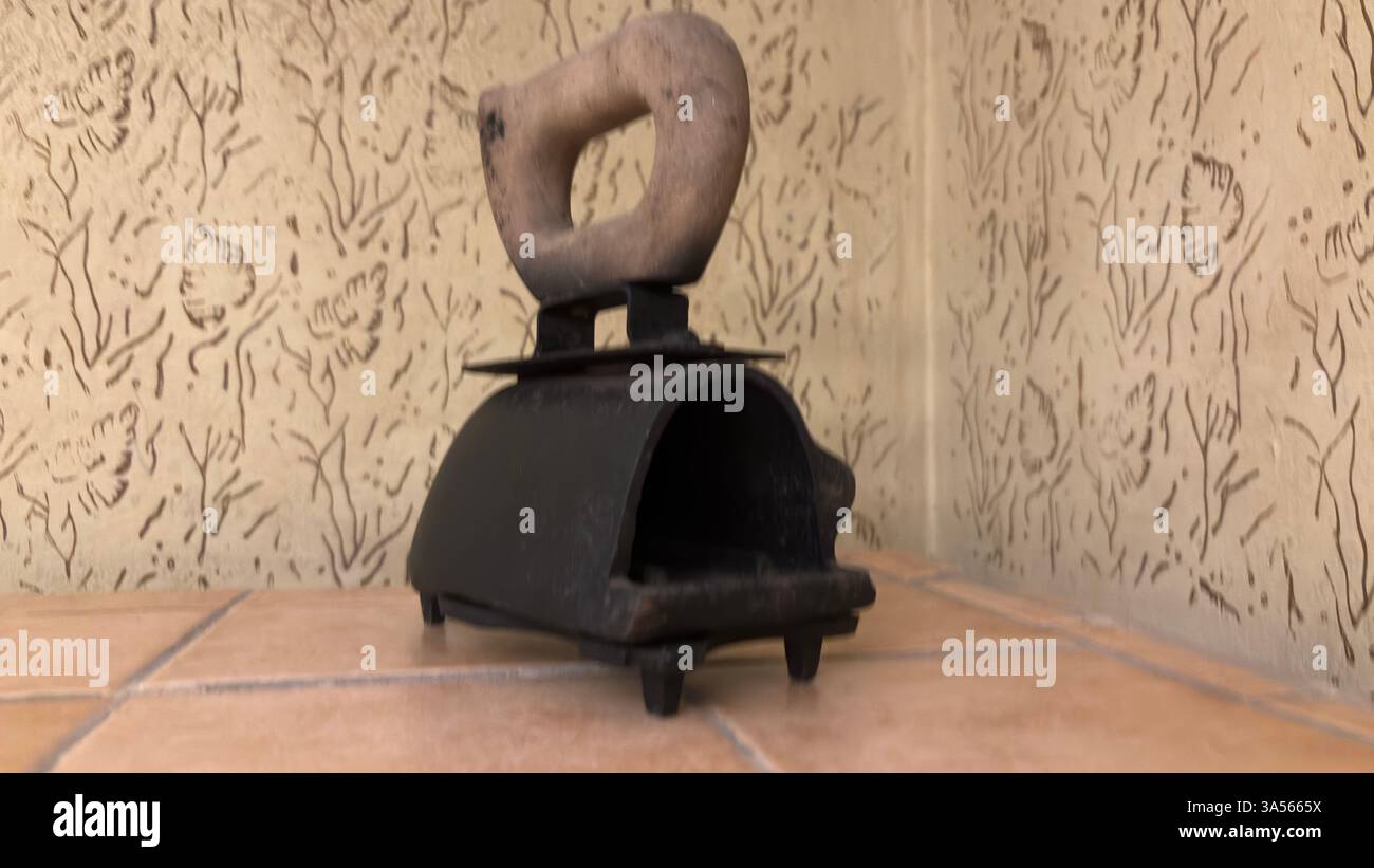 Gros plan du fer vintage de l'ère soviétique pour les vêtements. Appareil de cuisine en métal rétro original URSS polonais ustensiles de cuisine historiques. Poignée en bois - Image de stock capturée avec un smartphone