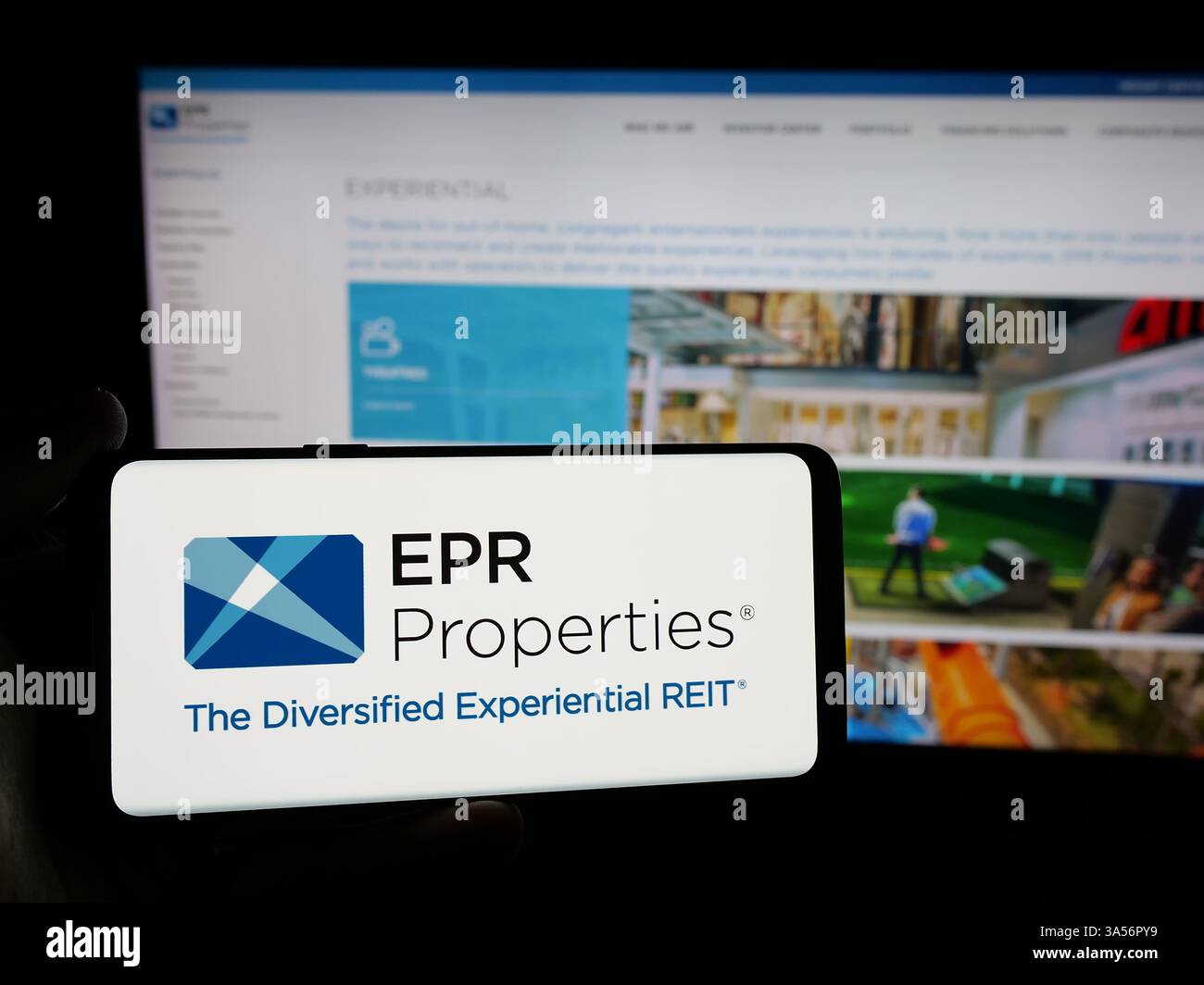 Stuttgart, Allemagne - 11-07-2024 : personne tenant un smartphone avec le logo de la société immobilière américaine EPR Properties sur l'écran en face du site Web. Banque D'Images