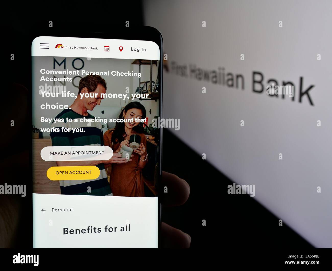 Stuttgart, Allemagne - 11-11-2024 : personne tenant un smartphone avec la page Web de la société de services financiers américaine First Hawaiian Inc sur l'écran avec le logo. Banque D'Images