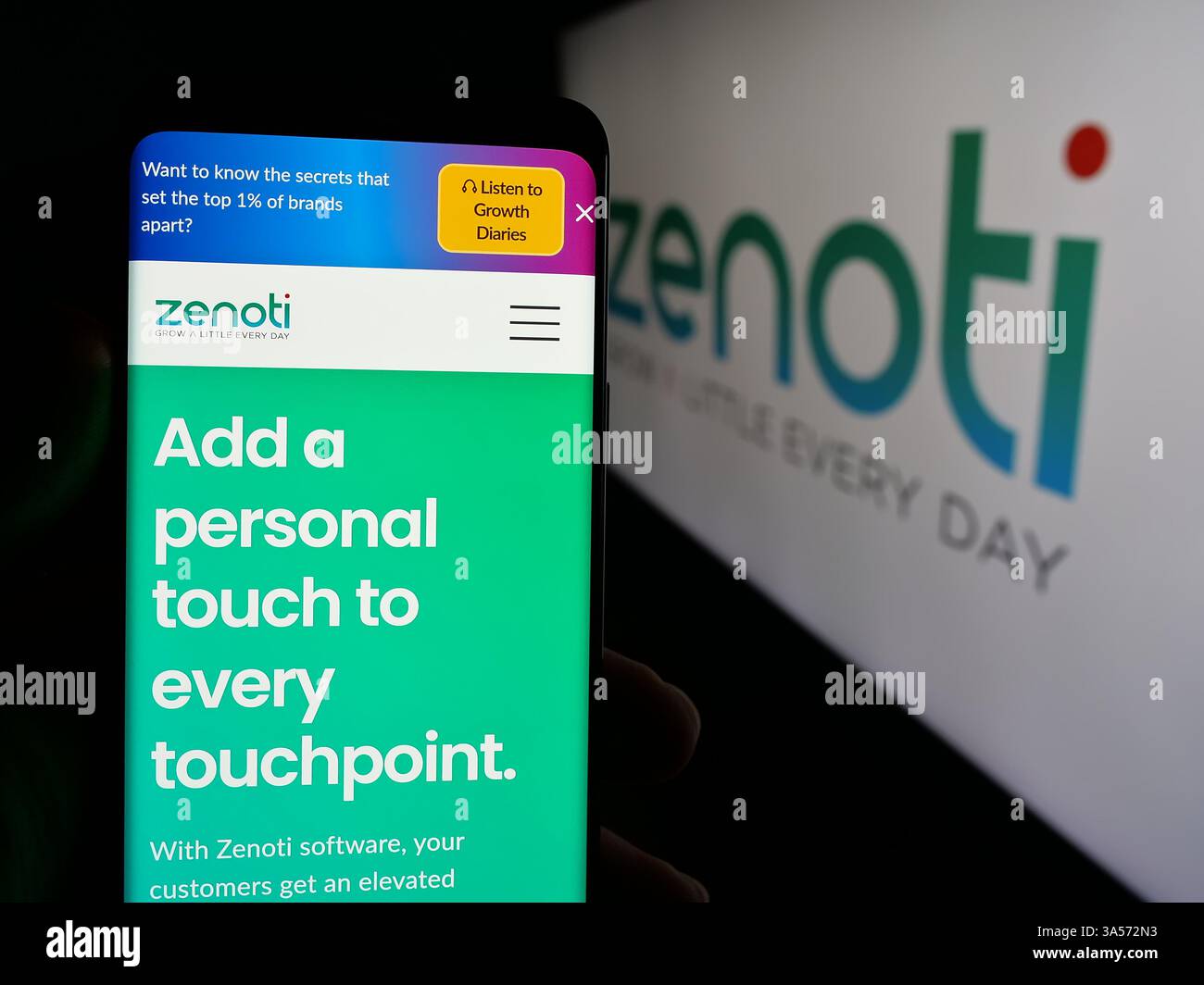 Stuttgart, Allemagne - 11-15-2024 : personne tenant le téléphone portable avec la page Web de la société américaine de logiciels de salon Soham Inc (Zenoti) sur l'écran avec le logo. Banque D'Images