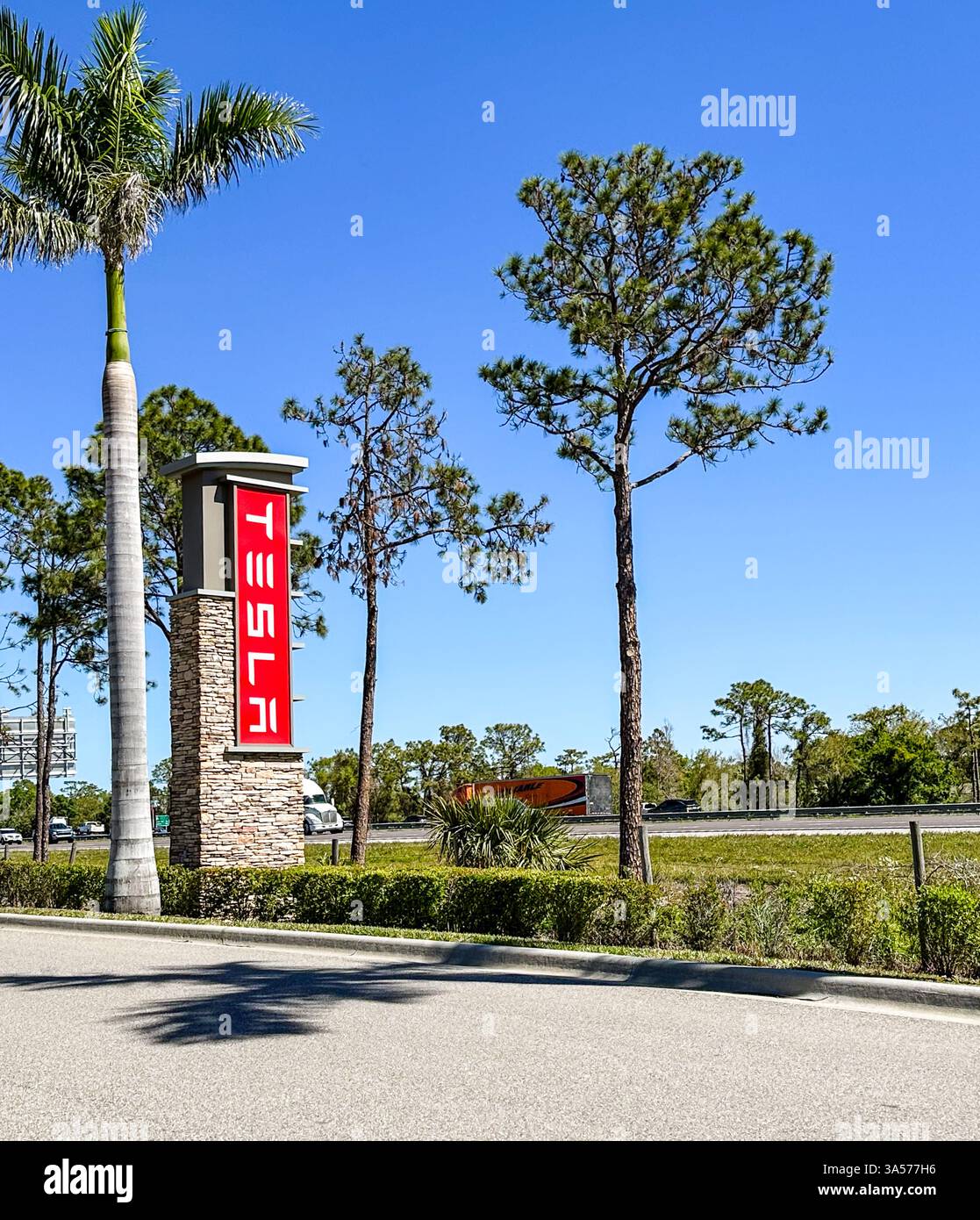 Le concessionnaire Tesla signe contre le ciel bleu. Bradenton, FL USA 19 mars 2025 - Image de stock capturée avec un smartphone Le concessionnaire Tesla signe contre le ciel bleu. Bradenton, FL USA 19 mars 2025 - Image de stock capturée avec un smartphone