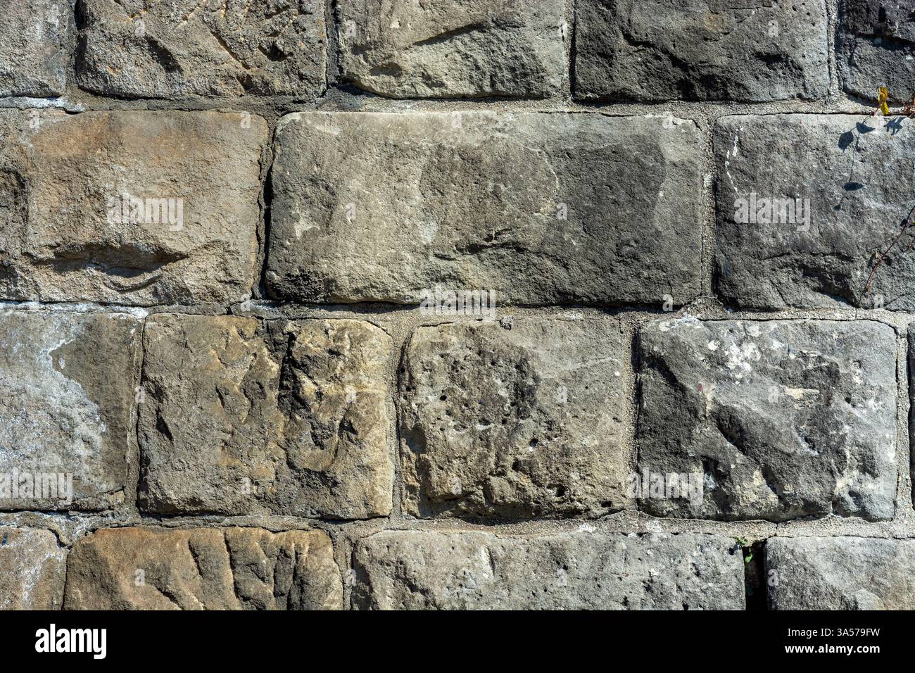 Fragment d'un vieux mur de blocs de pierre brute en gris pour une utilisation comme arrière-plans abstraits et textures. Banque D'Images