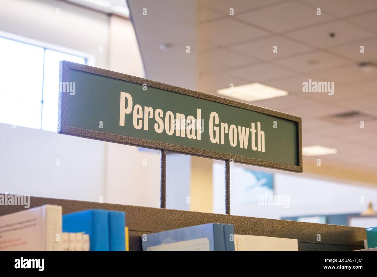 Une vue d'une allée de librairie et signe de genre pour les livres sur le sujet de croissance personnelle. Banque D'Images