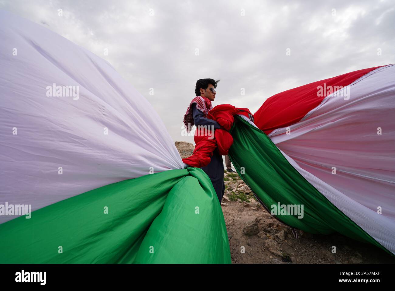 Un kurde irakien tient un énorme drapeau du Kurdistan lors des célébrations de la Journée du Novruz, un festival marquant le premier jour du printemps, nouvel an kurde et persan, dans la ville d'Akre, dans la région du Kurdistan. Nowruz, également connu sous le nom de nouvel an kurde et persan, est une célébration séculaire marquant l'arrivée du printemps et le début de la nouvelle année dans le calendrier persan. Observé par des millions de personnes à travers le moyen-Orient, l'Asie centrale, et au-delà, il symbolise le renouveau, l'espoir, et le triomphe de la lumière sur les ténèbres. Le festival comprend des traditions telles que les réunions de famille, les repas festifs et le pr Banque D'Images Un kurde irakien tient un énorme drapeau du Kurdistan lors des célébrations de la Journée du Novruz, un festival marquant le premier jour du printemps, nouvel an kurde et persan, dans la ville d'Akre, dans la région du Kurdistan. Nowruz, également connu sous le nom de nouvel an kurde et persan, est une célébration séculaire marquant l'arrivée du printemps et le début de la nouvelle année dans le calendrier persan. Observé par des millions de personnes à travers le moyen-Orient, l'Asie centrale, et au-delà, il symbolise le renouveau, l'espoir, et le triomphe de la lumière sur les ténèbres. Le festival comprend des traditions telles que les réunions de famille, les repas festifs et le pr Banque D'Images