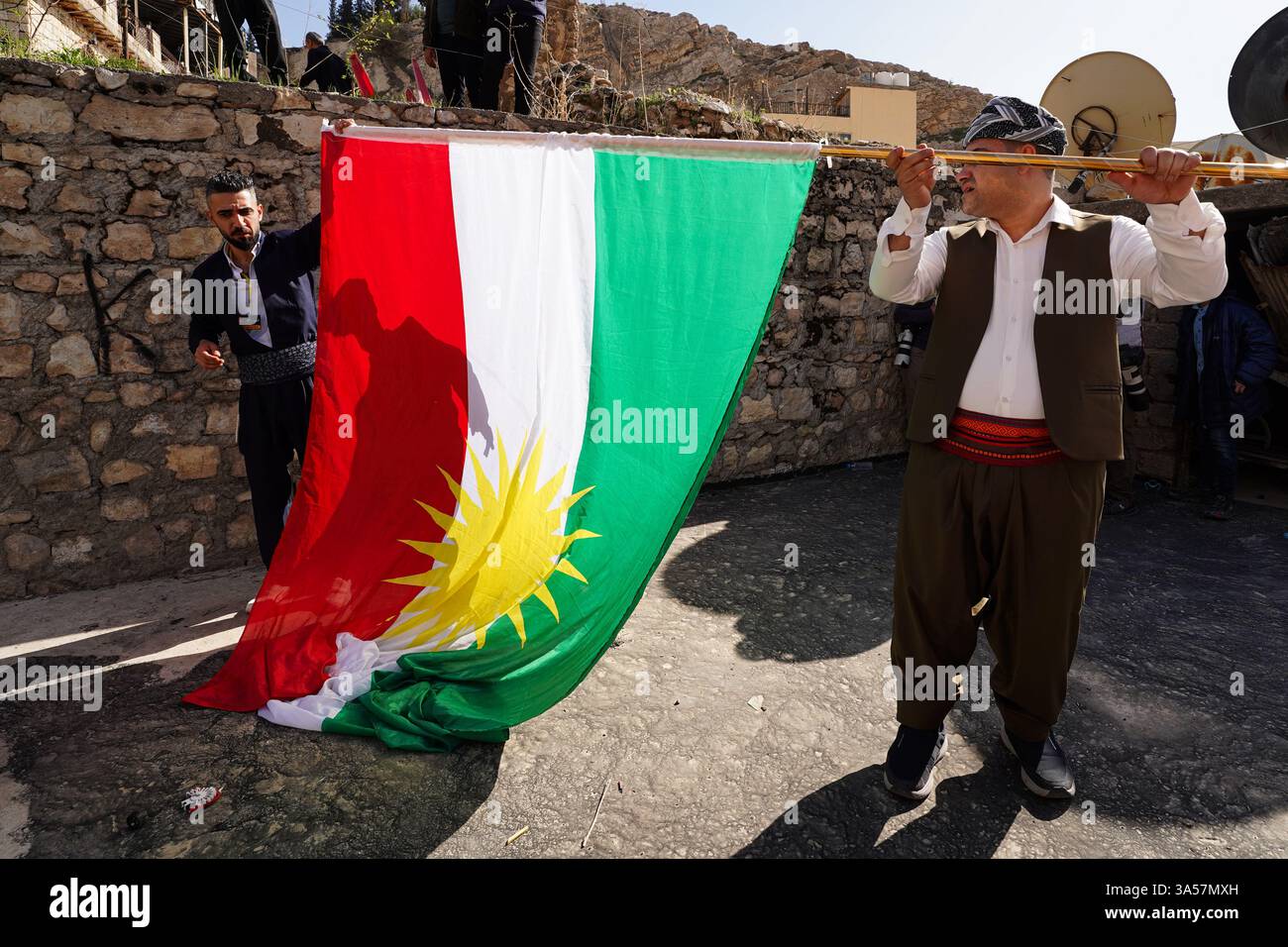 Les hommes kurdes irakiens portent un drapeau du Kurdistan lors des célébrations de la Journée du Novruz, un festival marquant le premier jour du printemps, nouvel an kurde et persan, dans la ville d'Akre, dans la région du Kurdistan. Nowruz, également connu sous le nom de nouvel an kurde et persan, est une célébration séculaire marquant l'arrivée du printemps et le début de la nouvelle année dans le calendrier persan. Observé par des millions de personnes à travers le moyen-Orient, l'Asie centrale, et au-delà, il symbolise le renouveau, l'espoir, et le triomphe de la lumière sur les ténèbres. Le festival comprend des traditions telles que les réunions de famille, les repas festifs et la préparation Banque D'Images Les hommes kurdes irakiens portent un drapeau du Kurdistan lors des célébrations de la Journée du Novruz, un festival marquant le premier jour du printemps, nouvel an kurde et persan, dans la ville d'Akre, dans la région du Kurdistan. Nowruz, également connu sous le nom de nouvel an kurde et persan, est une célébration séculaire marquant l'arrivée du printemps et le début de la nouvelle année dans le calendrier persan. Observé par des millions de personnes à travers le moyen-Orient, l'Asie centrale, et au-delà, il symbolise le renouveau, l'espoir, et le triomphe de la lumière sur les ténèbres. Le festival comprend des traditions telles que les réunions de famille, les repas festifs et la préparation Banque D'Images