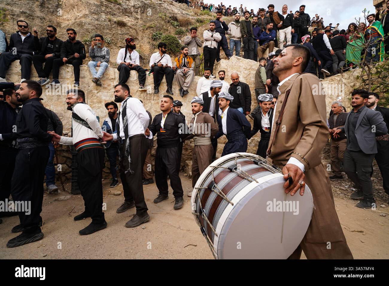 Les hommes kurdes irakiens dansent alors qu’ils célèbrent le jour du Novruz, un festival marquant le premier jour du printemps, nouvel an kurde et persan, dans la ville d’Akre, dans la région du Kurdistan. Nowruz, également connu sous le nom de nouvel an kurde et persan, est une célébration séculaire marquant l'arrivée du printemps et le début de la nouvelle année dans le calendrier persan. Observé par des millions de personnes à travers le moyen-Orient, l'Asie centrale, et au-delà, il symbolise le renouveau, l'espoir, et le triomphe de la lumière sur les ténèbres. Le festival comprend des traditions telles que des réunions de famille, des repas festifs et la préparation d'un onglet 'Haft-Seen' Banque D'Images