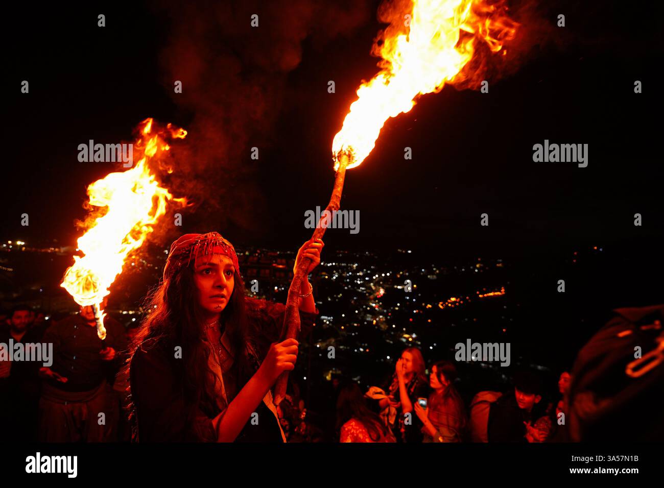 Une femme kurde irakienne porte une torche de feu alors que les gens célèbrent le jour de Nowruz, un festival marquant le premier jour du printemps, nouvel an kurde et persan, dans la ville d'Akre, dans la région du Kurdistan. Nowruz, également connu sous le nom de nouvel an kurde et persan, est une célébration séculaire marquant l'arrivée du printemps et le début de la nouvelle année dans le calendrier persan. Observé par des millions de personnes à travers le moyen-Orient, l'Asie centrale, et au-delà, il symbolise le renouveau, l'espoir, et le triomphe de la lumière sur les ténèbres. Le festival comprend des traditions telles que les réunions de famille, les repas festifs et la préparation Banque D'Images Une femme kurde irakienne porte une torche de feu alors que les gens célèbrent le jour de Nowruz, un festival marquant le premier jour du printemps, nouvel an kurde et persan, dans la ville d'Akre, dans la région du Kurdistan. Nowruz, également connu sous le nom de nouvel an kurde et persan, est une célébration séculaire marquant l'arrivée du printemps et le début de la nouvelle année dans le calendrier persan. Observé par des millions de personnes à travers le moyen-Orient, l'Asie centrale, et au-delà, il symbolise le renouveau, l'espoir, et le triomphe de la lumière sur les ténèbres. Le festival comprend des traditions telles que les réunions de famille, les repas festifs et la préparation Banque D'Images