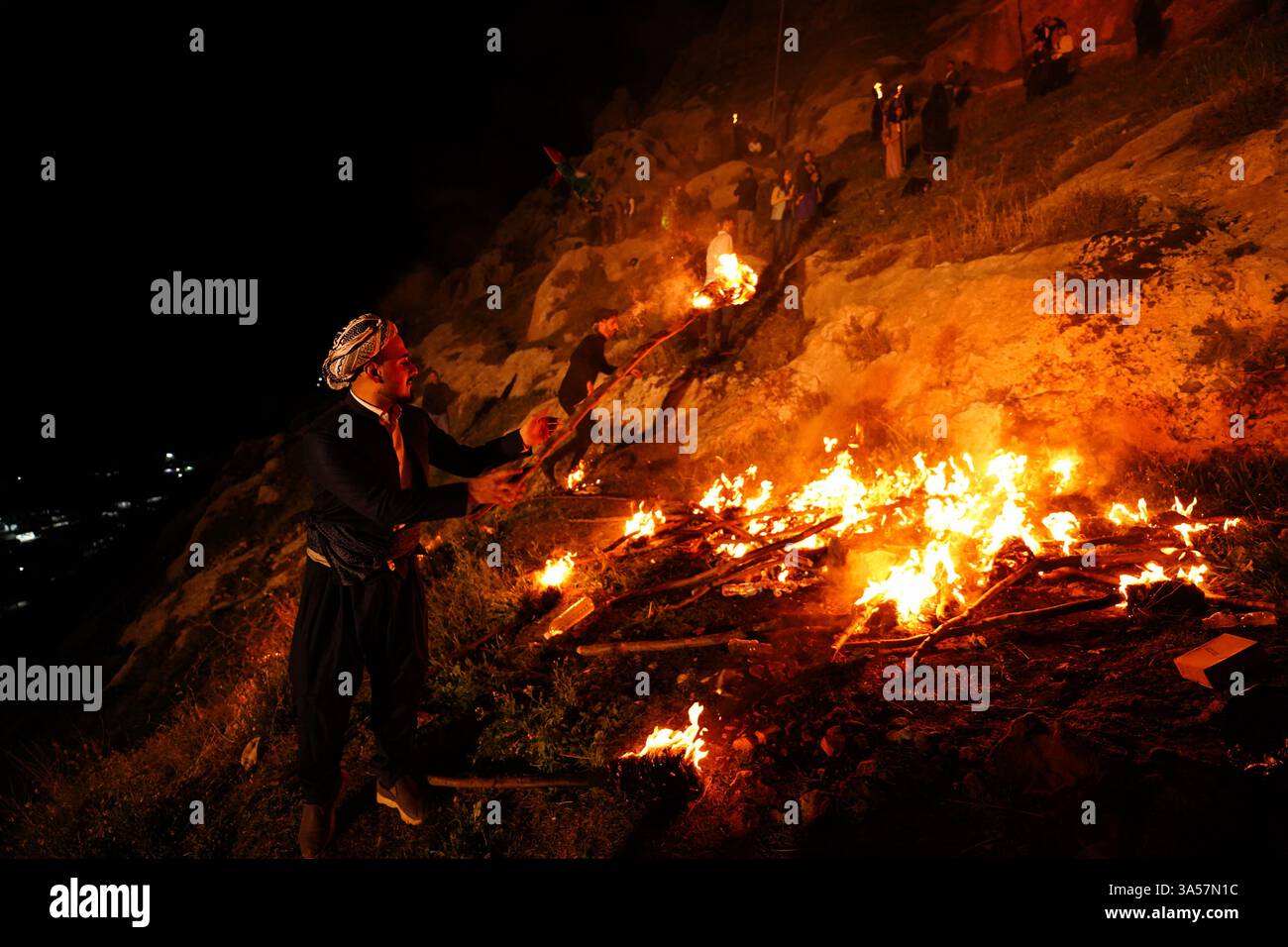 Un kurde irakien porte une torche de feu alors que les gens célèbrent le jour de Nowruz, un festival marquant le premier jour du printemps, nouvel an kurde et persan, dans la ville d'Akre, dans la région du Kurdistan. Nowruz, également connu sous le nom de nouvel an kurde et persan, est une célébration séculaire marquant l'arrivée du printemps et le début de la nouvelle année dans le calendrier persan. Observé par des millions de personnes à travers le moyen-Orient, l'Asie centrale, et au-delà, il symbolise le renouveau, l'espoir, et le triomphe de la lumière sur les ténèbres. Le festival comprend des traditions telles que les réunions de famille, les repas festifs et la préparation Banque D'Images Un kurde irakien porte une torche de feu alors que les gens célèbrent le jour de Nowruz, un festival marquant le premier jour du printemps, nouvel an kurde et persan, dans la ville d'Akre, dans la région du Kurdistan. Nowruz, également connu sous le nom de nouvel an kurde et persan, est une célébration séculaire marquant l'arrivée du printemps et le début de la nouvelle année dans le calendrier persan. Observé par des millions de personnes à travers le moyen-Orient, l'Asie centrale, et au-delà, il symbolise le renouveau, l'espoir, et le triomphe de la lumière sur les ténèbres. Le festival comprend des traditions telles que les réunions de famille, les repas festifs et la préparation Banque D'Images