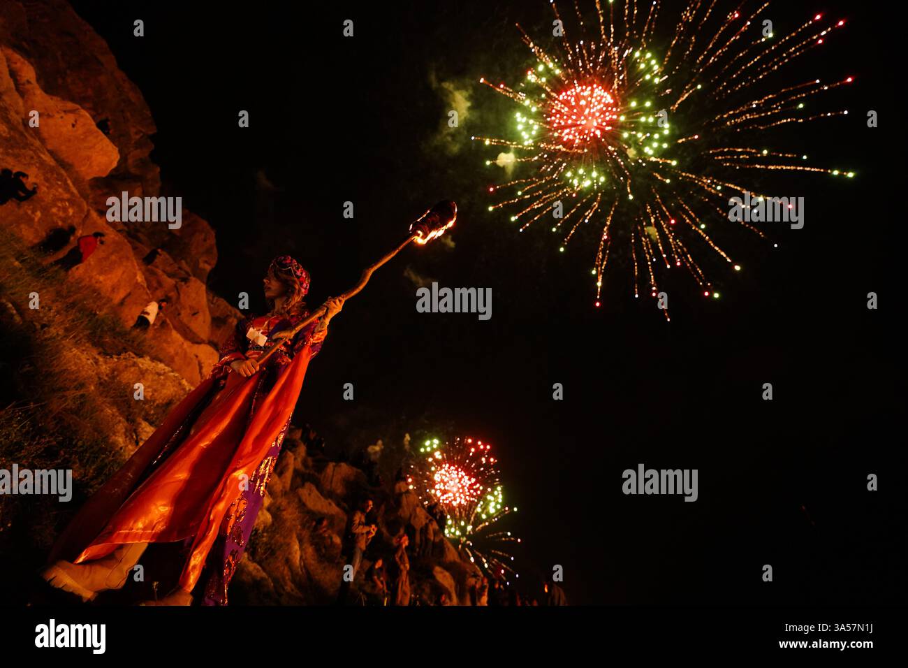 Une femme kurde irakienne porte une torche de feu tandis que des feux d'artifice illuminent la ville d'Akre dans la région du Kurdistan, lors des célébrations du jour du Novruz, un festival marquant le premier jour du printemps, le nouvel an kurde et persan. Nowruz, également connu sous le nom de nouvel an kurde et persan, est une célébration séculaire marquant l'arrivée du printemps et le début de la nouvelle année dans le calendrier persan. Observé par des millions de personnes à travers le moyen-Orient, l'Asie centrale, et au-delà, il symbolise le renouveau, l'espoir, et le triomphe de la lumière sur les ténèbres. Le festival comprend des traditions telles que les réunions de famille, les repas festifs, Banque D'Images Une femme kurde irakienne porte une torche de feu tandis que des feux d'artifice illuminent la ville d'Akre dans la région du Kurdistan, lors des célébrations du jour du Novruz, un festival marquant le premier jour du printemps, le nouvel an kurde et persan. Nowruz, également connu sous le nom de nouvel an kurde et persan, est une célébration séculaire marquant l'arrivée du printemps et le début de la nouvelle année dans le calendrier persan. Observé par des millions de personnes à travers le moyen-Orient, l'Asie centrale, et au-delà, il symbolise le renouveau, l'espoir, et le triomphe de la lumière sur les ténèbres. Le festival comprend des traditions telles que les réunions de famille, les repas festifs, Banque D'Images