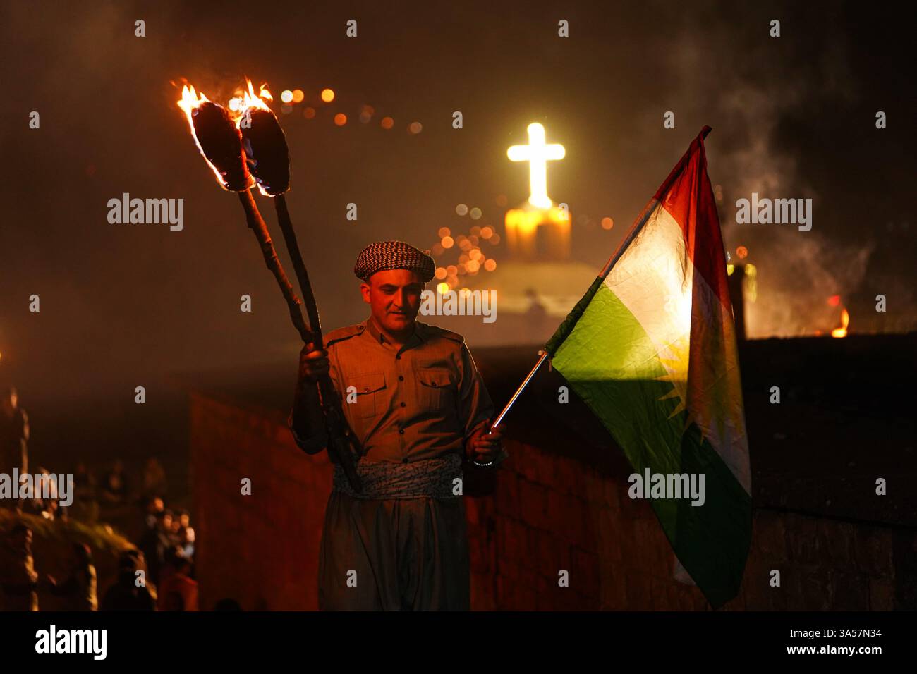 Un kurde irakien porte une torche de feu et le drapeau du Kurdistan alors que les gens célèbrent le jour du Novruz, un festival marquant le premier jour du printemps, nouvel an kurde et persan, dans la ville d'Akre, dans la région du Kurdistan. Nowruz, également connu sous le nom de nouvel an kurde et persan, est une célébration séculaire marquant l'arrivée du printemps et le début de la nouvelle année dans le calendrier persan. Observé par des millions de personnes à travers le moyen-Orient, l'Asie centrale, et au-delà, il symbolise le renouveau, l'espoir, et le triomphe de la lumière sur les ténèbres. Le festival comprend des traditions telles que les réunions de famille, les repas de fête, un Banque D'Images Un kurde irakien porte une torche de feu et le drapeau du Kurdistan alors que les gens célèbrent le jour du Novruz, un festival marquant le premier jour du printemps, nouvel an kurde et persan, dans la ville d'Akre, dans la région du Kurdistan. Nowruz, également connu sous le nom de nouvel an kurde et persan, est une célébration séculaire marquant l'arrivée du printemps et le début de la nouvelle année dans le calendrier persan. Observé par des millions de personnes à travers le moyen-Orient, l'Asie centrale, et au-delà, il symbolise le renouveau, l'espoir, et le triomphe de la lumière sur les ténèbres. Le festival comprend des traditions telles que les réunions de famille, les repas de fête, un Banque D'Images
