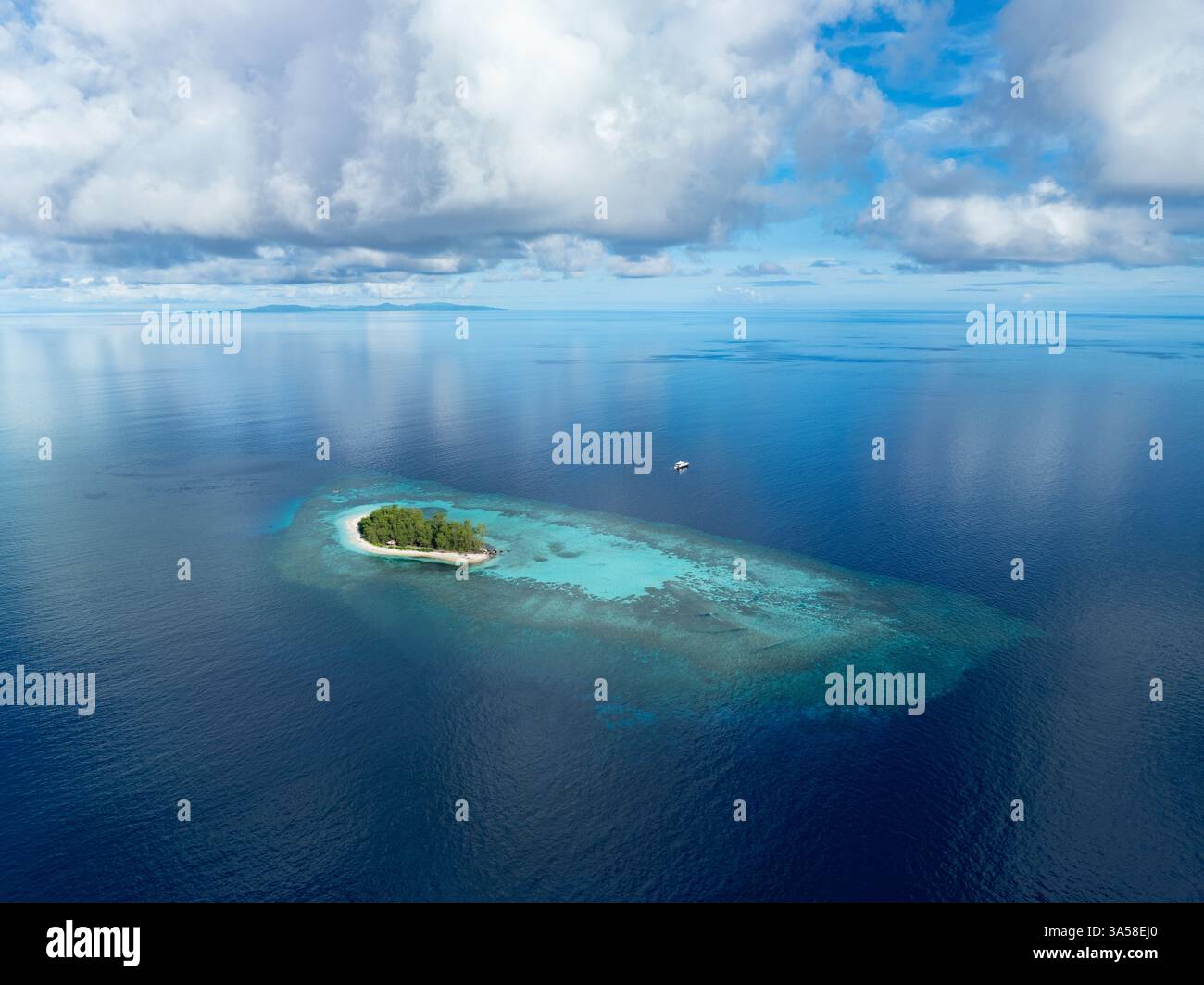 Un magnifique récif corallien encercle une île tropicale idyllique dans les îles Togian d'Indonésie. Cette belle région fait partie du Triangle de corail. Banque D'Images