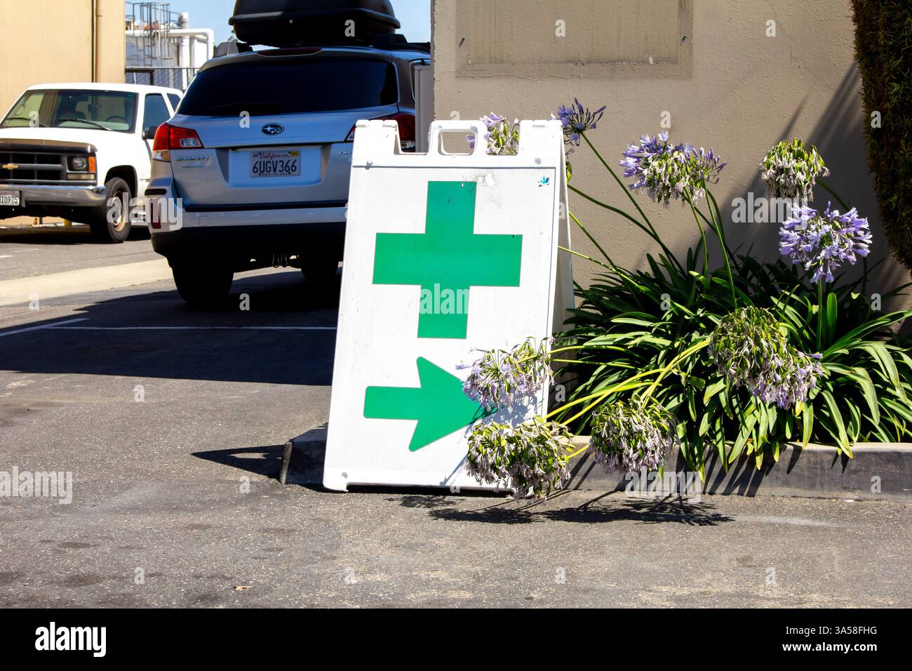 Los Angeles, Californie, États-Unis - 07-02-2019 : une vue d'une croix verte et d'une flèche dirigeant les clients vers un dispensaire de marijuana à proximité. Banque D'Images