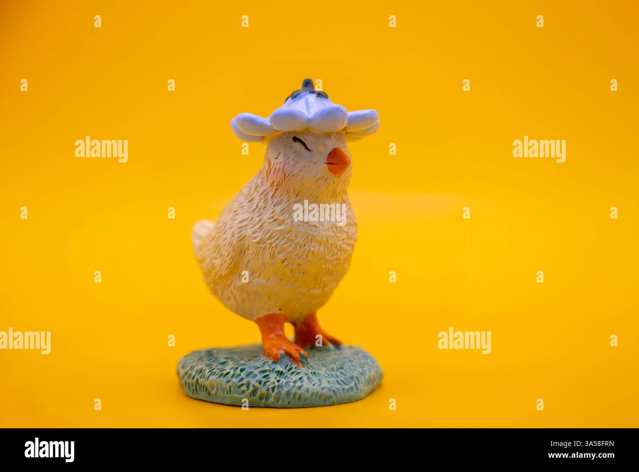 Un mignon poussin décoratif de Pâques sur un fond jaune Uni chaud. Parfait pour Pâques et les cartes de printemps, le papier peint et les dessins Banque D'Images