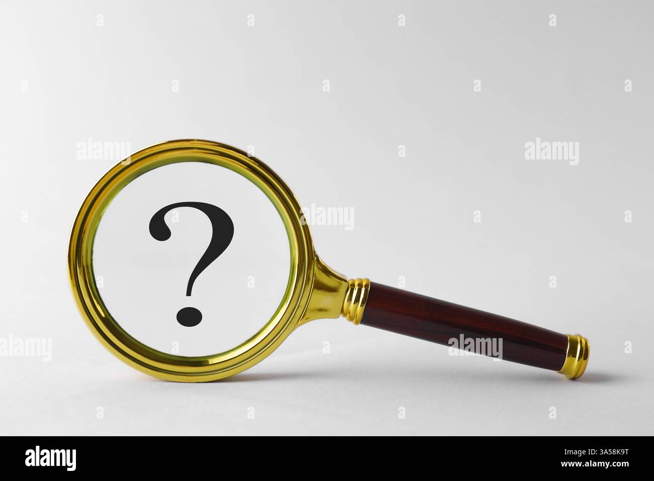 Point d'interrogation sur fond clair, vue à travers la loupe Banque D'Images