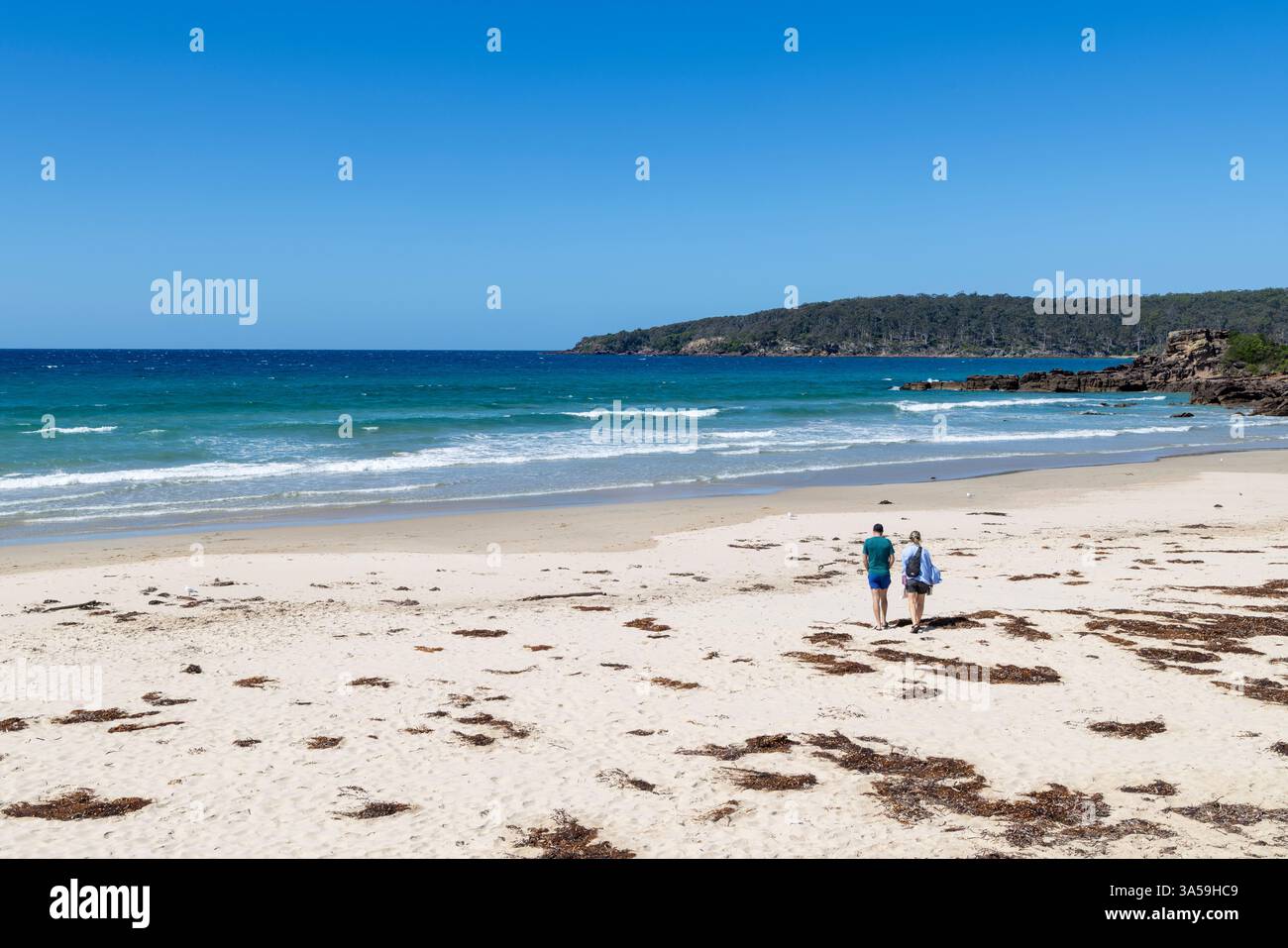 Plage de Pambula près de Merimbula sur la côte de saphir de Nouvelle-Galles du Sud, couple adulte marchant ensemble à travers le sable, Nouvelle-Galles du Sud, Australie Banque D'Images