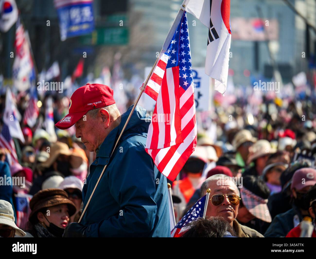 Séoul, Corée du Sud. 22 mars 2025. Un partisan du président destitué Yoon Suk Yeol porte des drapeaux sud-coréens et américains lors d'un rassemblement sur la place Gwanghwamun dans le centre-ville de Séoul, Corée du Sud, le samedi 22 mars 2025. Le pays attend avec impatience un verdict de la Cour constitutionnelle sur la confirmation de sa destitution. Photo de Thomas Maresca/UPI crédit : UPI/Alamy Live News Banque D'Images