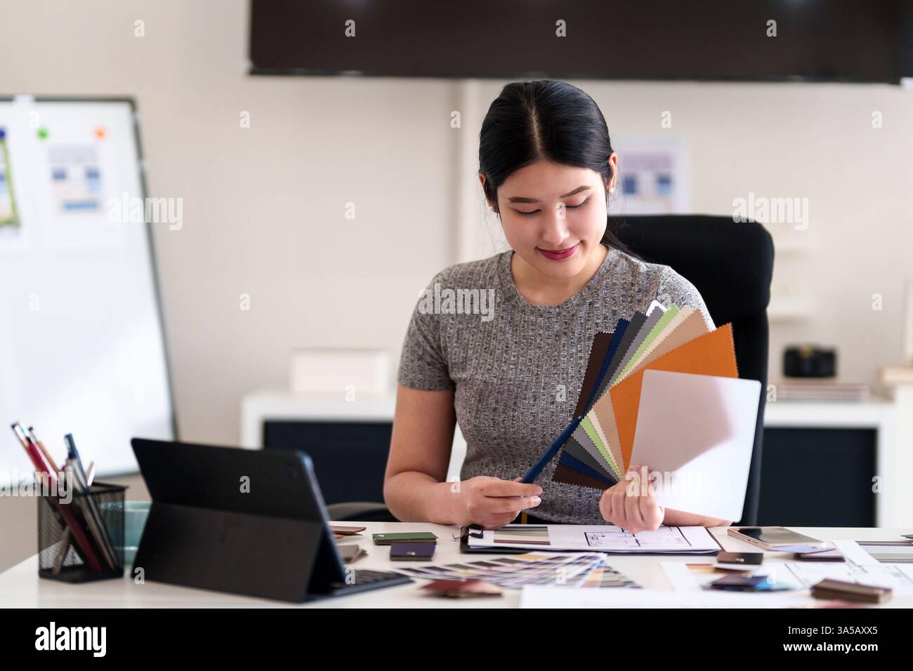 Jeune architecte présentant des idées de design d'intérieur à travers la tablette lors de la réunion en ligne dans le bureau créatif Banque D'Images
