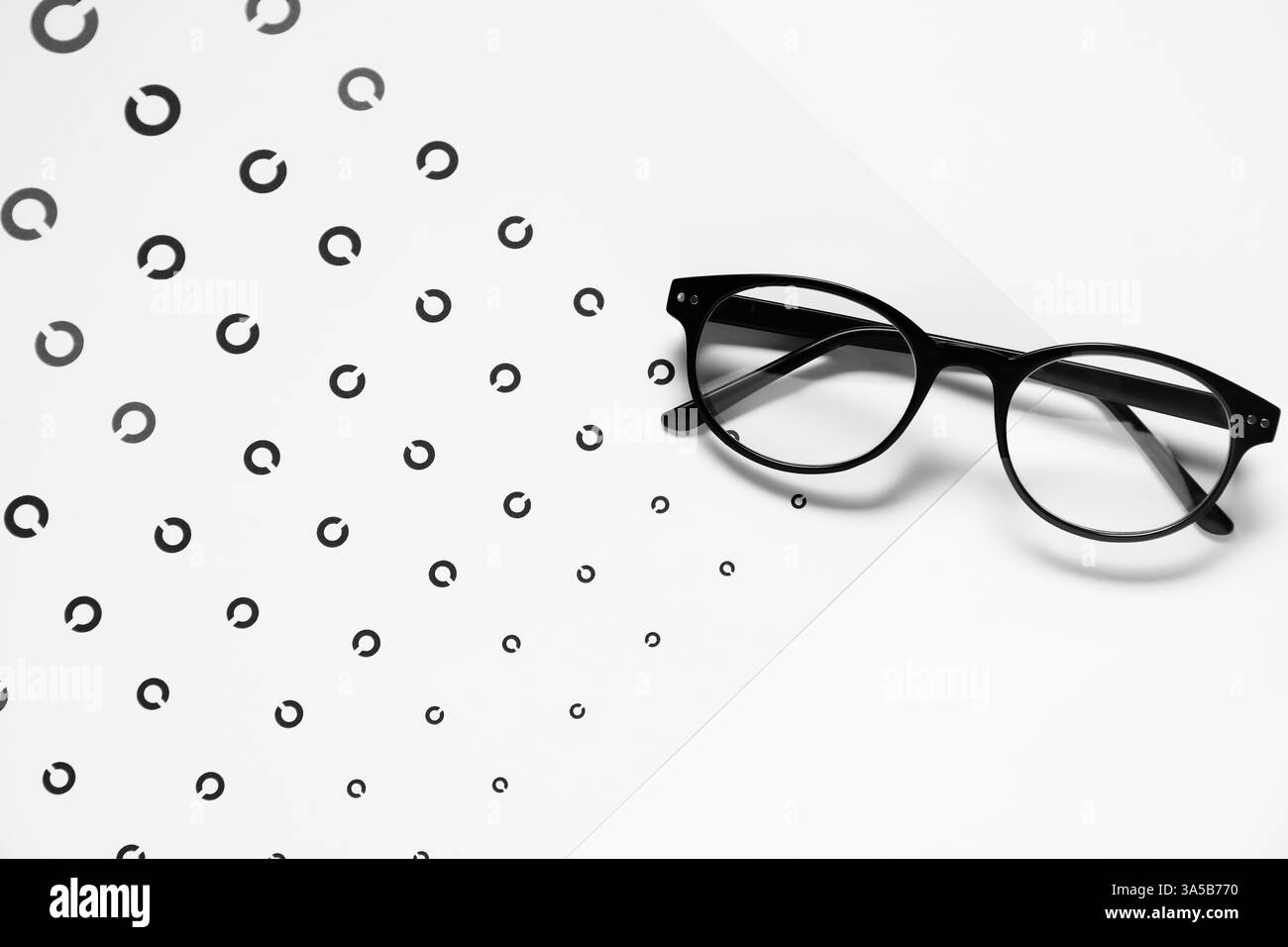 Lunettes et tableau de test de vision sur fond blanc, vue de dessus Banque D'Images