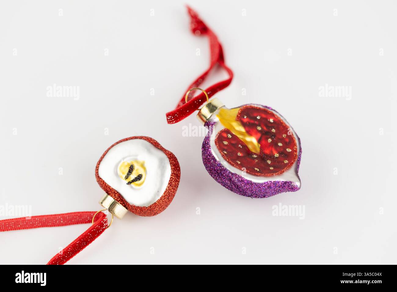 Les jouets d'arbre de Noël en forme de pomme reposent sur un fond blanc et des figues sur une corde rouge en verre jouets du nouvel an décor moderne Banque D'Images