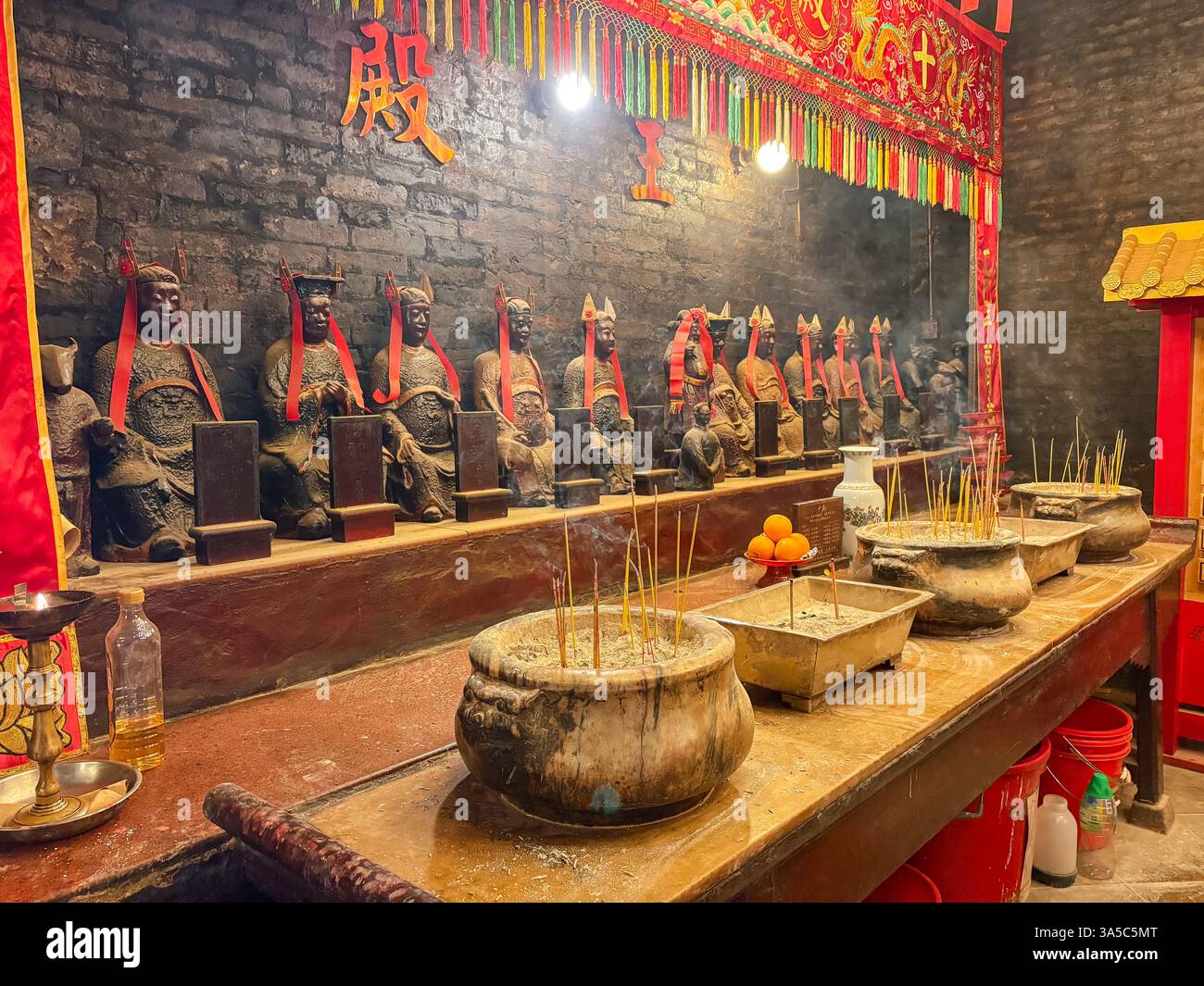 Vue intérieure du temple Man Mo à Hong Kong. Encens brûlant devant des statues de divinité, un lieu de culte et une signification culturelle. Banque D'Images