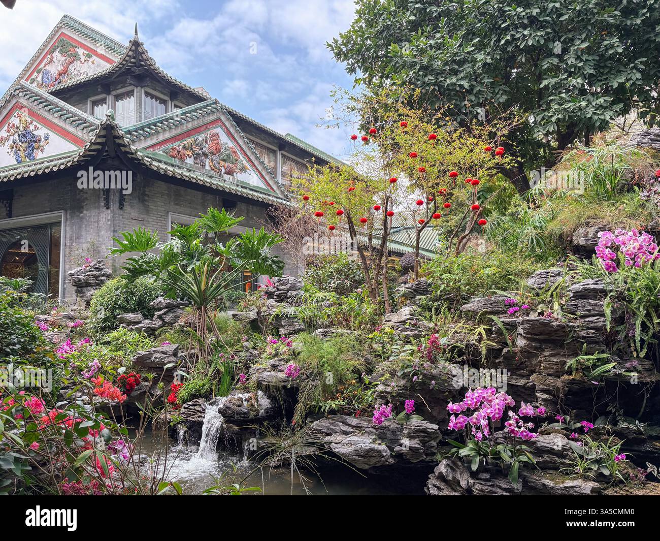 Restaurant chinois décoré à Guangzhou avec des fleurs, des rochers, une petite cascade et des lanternes rouges. Banque D'Images