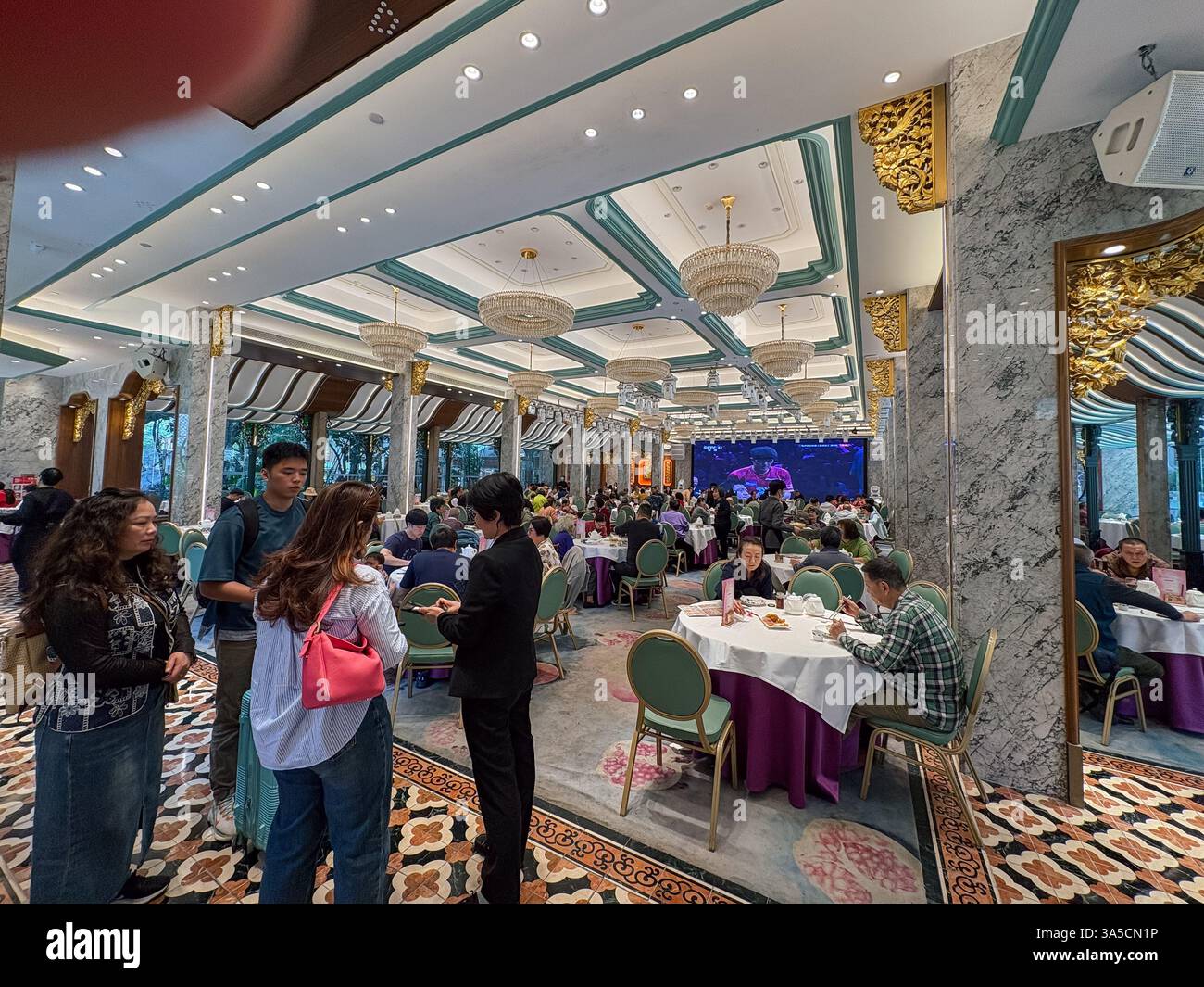 L'ambiance à l'intérieur d'un restaurant chinois animé à Guangzhou, avec de nombreuses personnes dînant. Banque D'Images