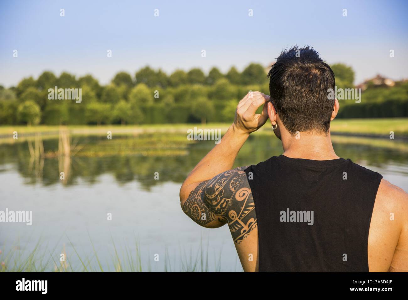Dos d'homme musclé avec tatouage posant dans le jardin de luxe européen au palais royal Venaria Reale près de Turin, Italie, Europe Banque D'Images