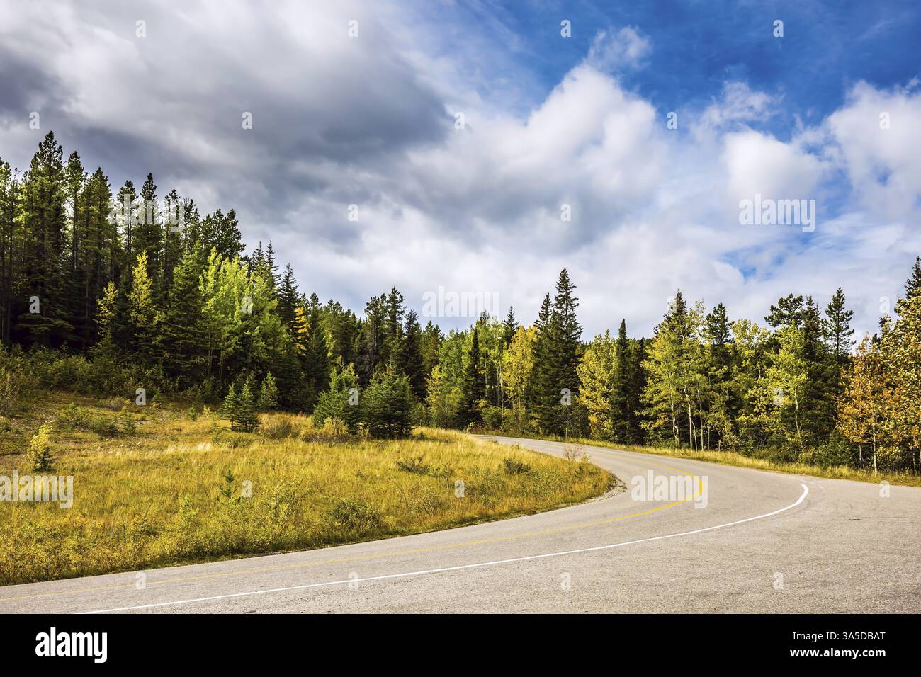 Parfait coucher de soleil de tempête sur les montagnes Rocheuses. La route est parmi la magnifique forêt d'automne Banque D'Images