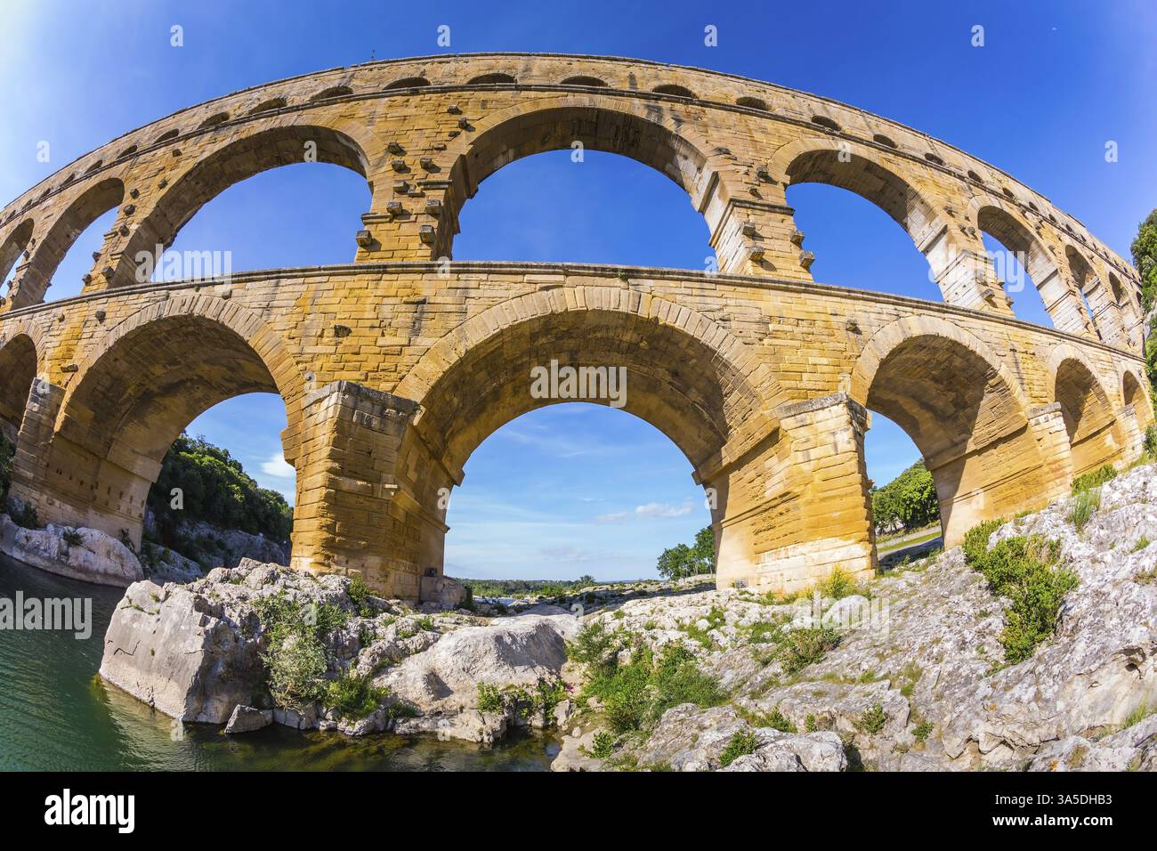 Pont aqueduc à trois étages Pont du Gard a été construit à l'époque romaine sur le Gardon. Coucher de soleil Provence. Objectif fisheye photo Banque D'Images