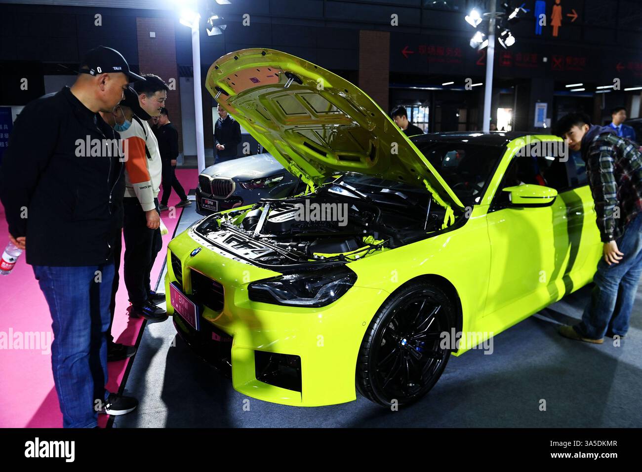 Les visiteurs regardent les véhicules exposés à Qingdao, dans la province du Shandong, en Chine, le 22 mars 2025. Banque D'Images