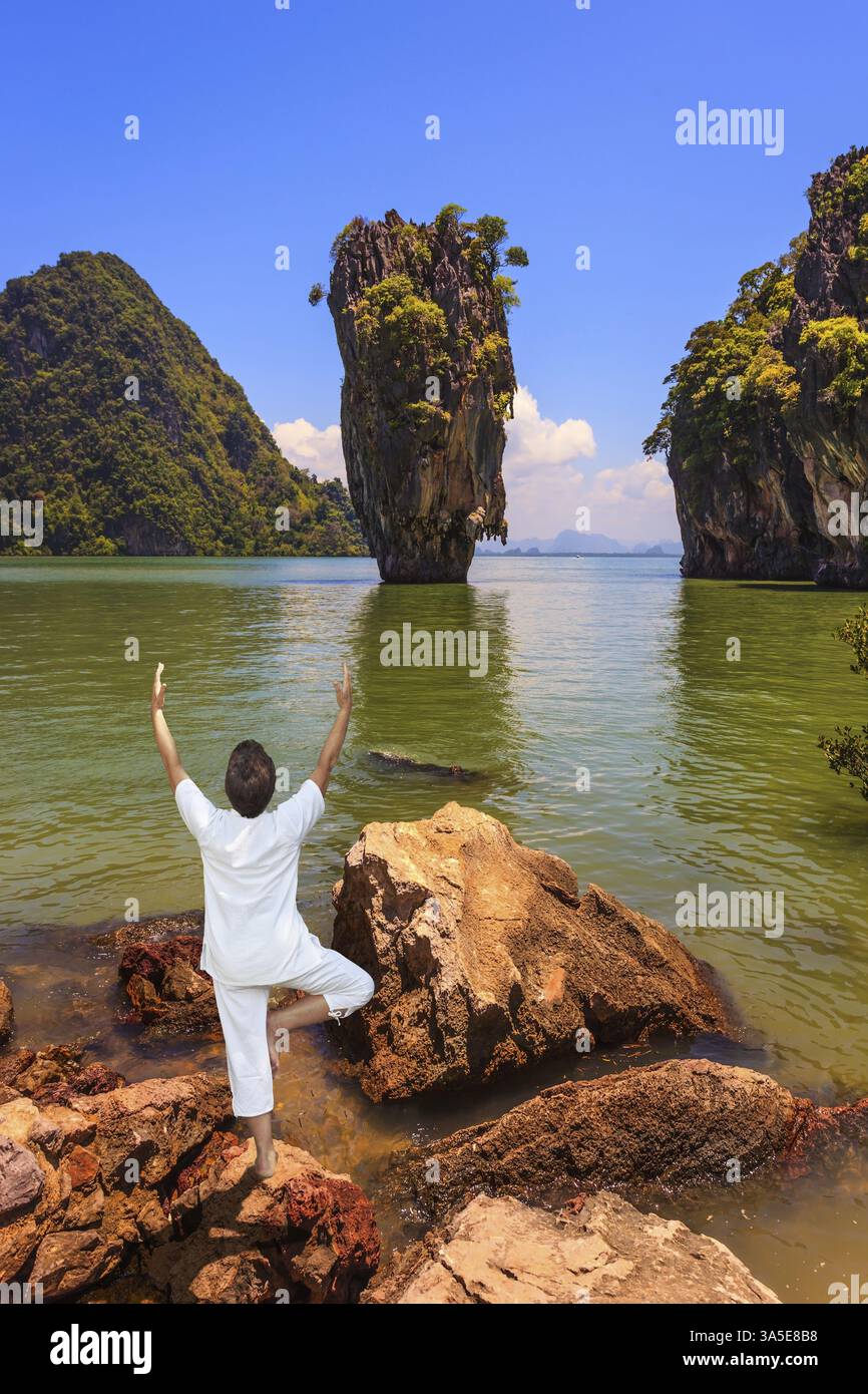 Femme effectue yoga pose Tree sur la rive de la mer d'Andaman. Vacances exotiques en Thaïlande Banque D'Images