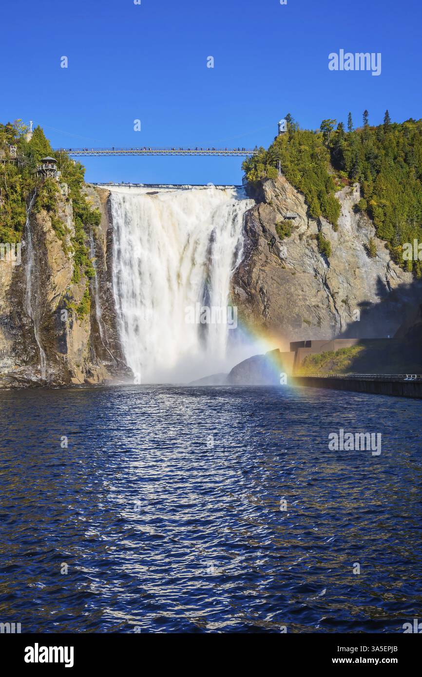 Le magnifique arc-en-ciel joue dans les éclaboussures de chutes. Le lac bleu et la puissante cascade Montmorency dans le parc des chutes Montmorency, au Québec. Le concept de Banque D'Images
