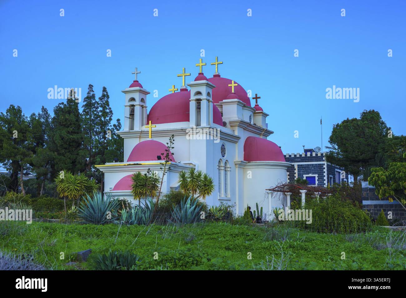 Dômes roses et croix dorées couronnées d'un bâtiment d'église blanc comme neige. Église grecque de la cathédrale des douze apôtres en Israël Banque D'Images