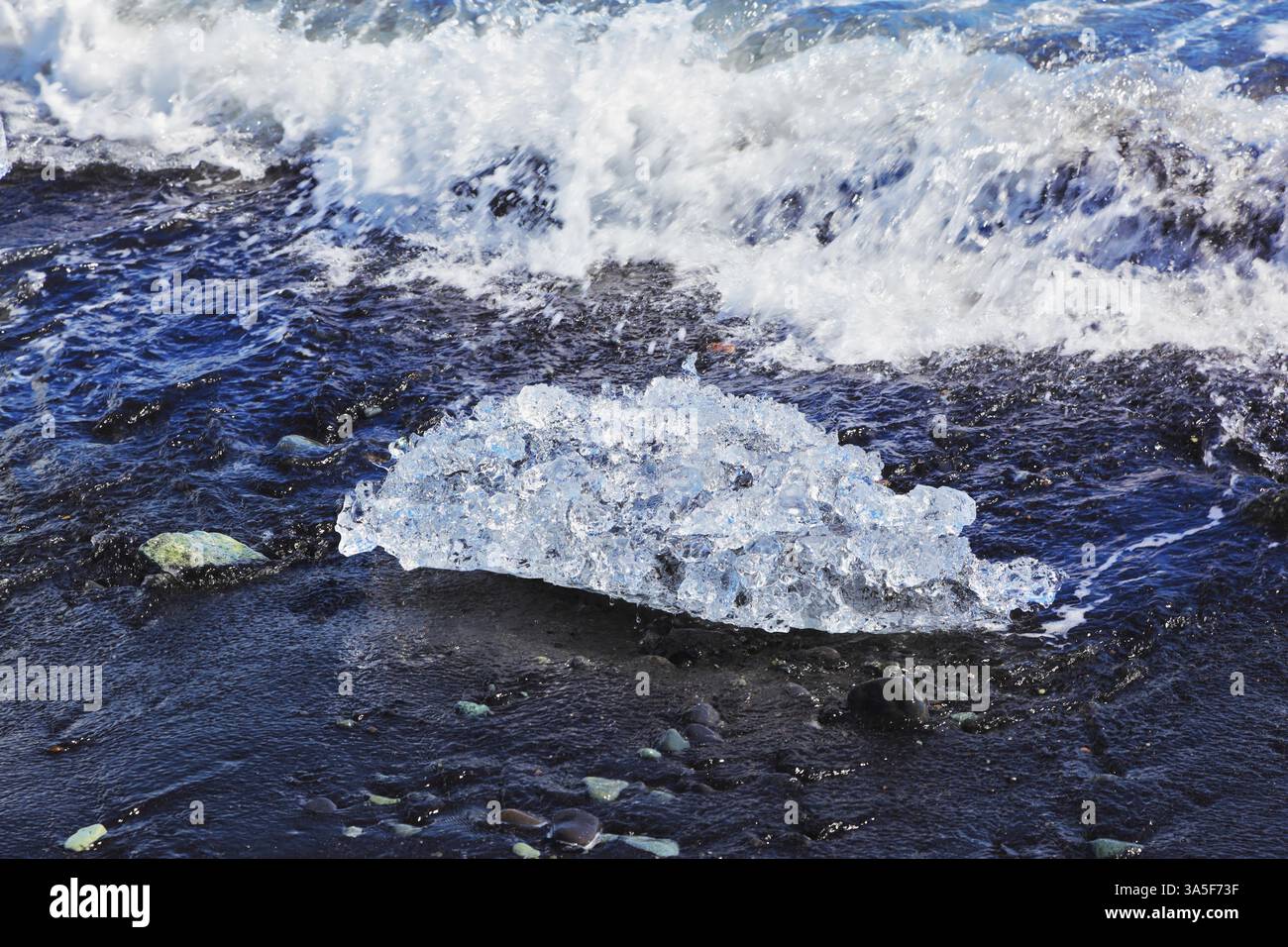 L'océan Arctique. Islande. Flottant ices Yokulsaurloun lagon sur la plage avec sable noir Banque D'Images