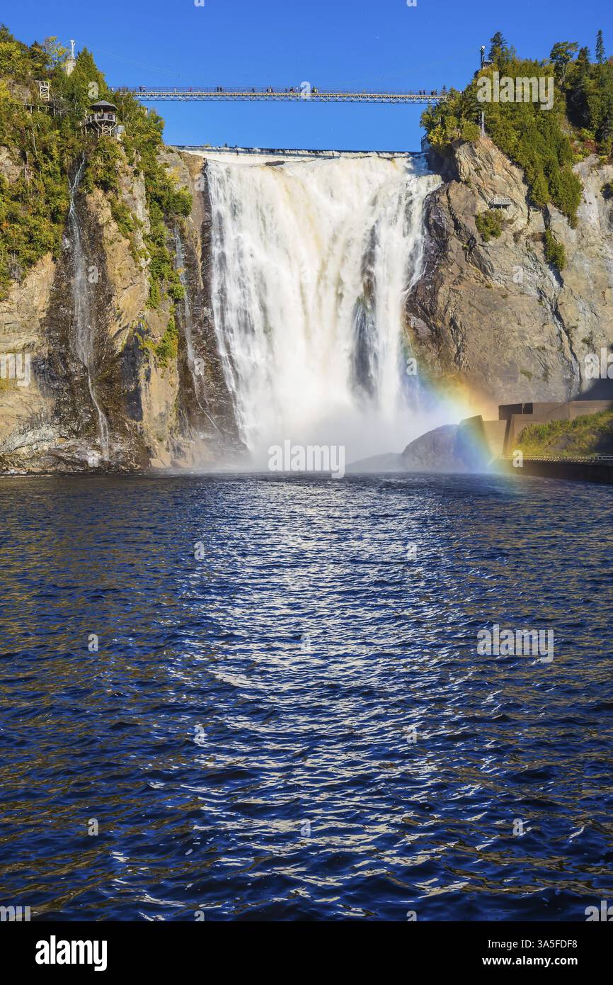 Le magnifique arc-en-ciel joue dans les éclaboussures de chutes. Le lac bleu et la puissante cascade Montmorency dans le parc des chutes Montmorency, au Québec. Le concept de Banque D'Images