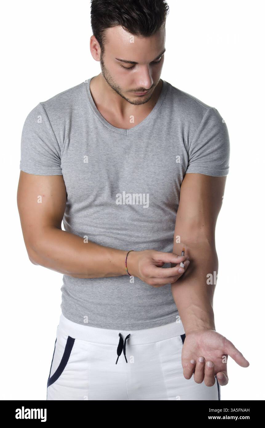 Jeune homme musclé l'injection de médicament ou de prendre le sang de son bras avec une seringue Banque D'Images