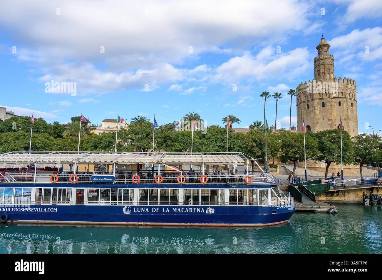 Embarcation à passagers Luna de la Macarena amarrée dans le fleuve Guadalquivir, avec la Torre del Oro médiévale à droite. Banque D'Images