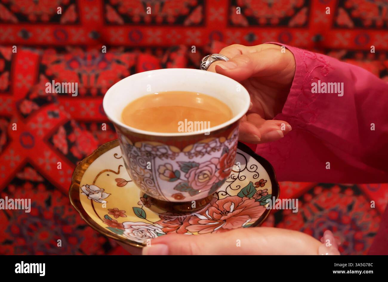 Femme se relaxant avec une tasse de thé Masala Chai fraîchement infusé Banque D'Images