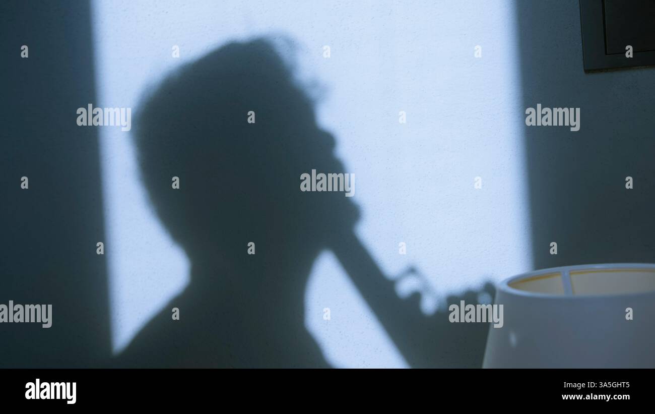 Ombre silhouette d'un homme avec un pistolet - tension psychologique et lutte intérieure Banque D'Images