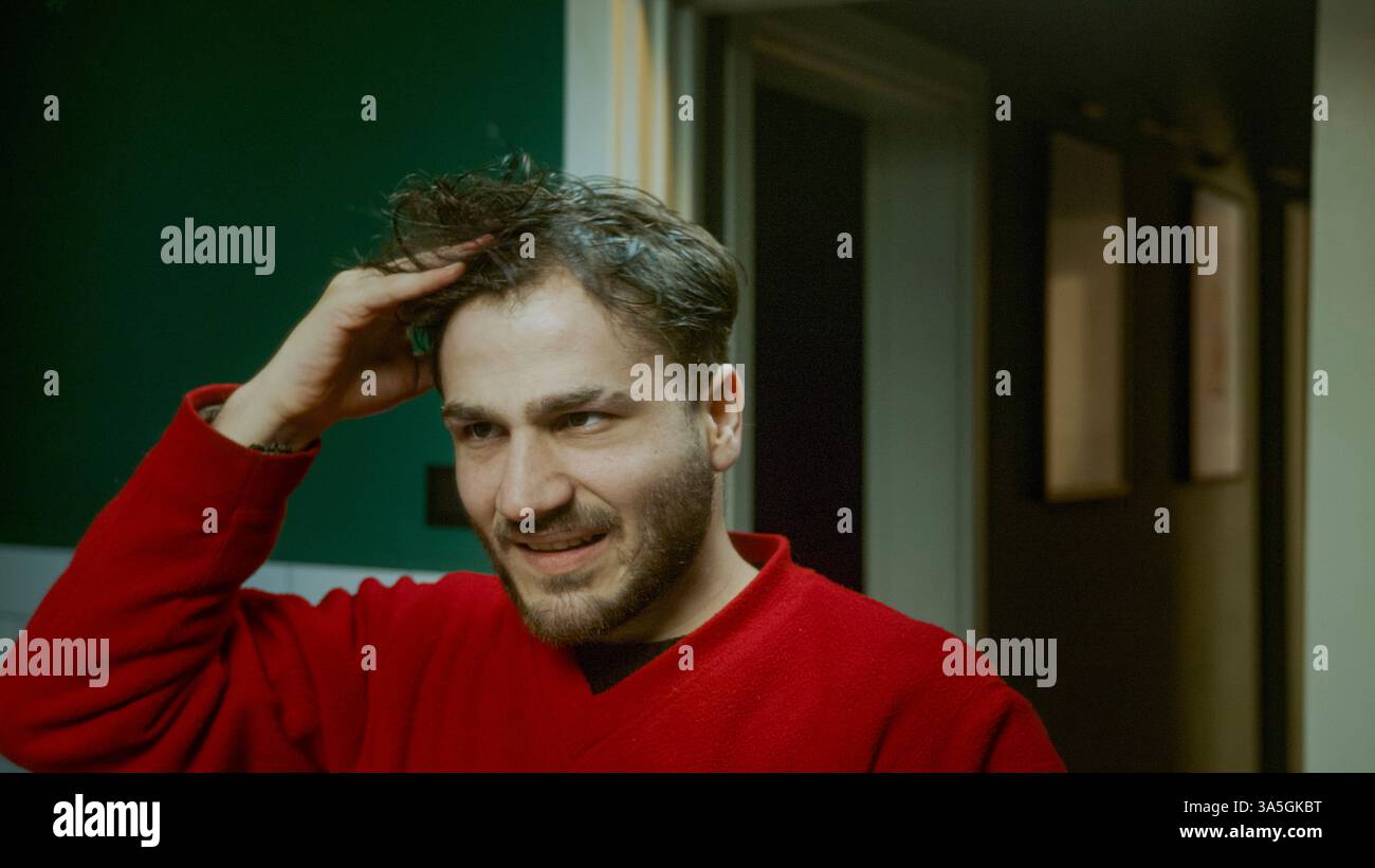 Jeune homme appliquant le sérum de perte de cheveux semblant stressé inquiet de l'amincissement des cheveux et la santé des cheveux en utilisant le traitement dans la routine quotidienne de toilettage Banque D'Images