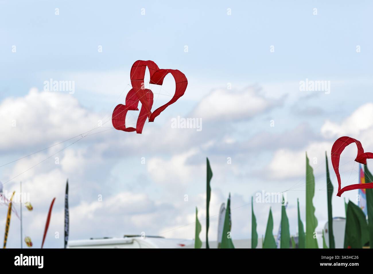 Deux cerfs-volants rouges en forme de cœur volant entrelacés dans le ciel, texte espace libre, festival de cerf-volant à Vinsebeck, Steinheim, parc naturel Eggebirge et sou Banque D'Images