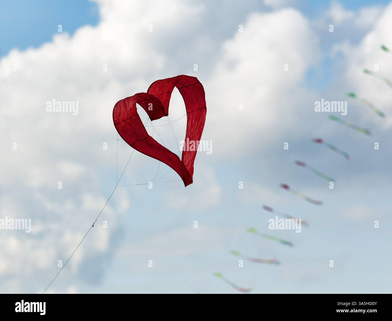 Cerf-volant en forme de cœur, cœur rouge, ciel nuageux, festival de cerf-volant à Vinsebeck, Steinheim, Eggebirge et parc naturel de la forêt sud de Teutoburg, Weserberg Banque D'Images