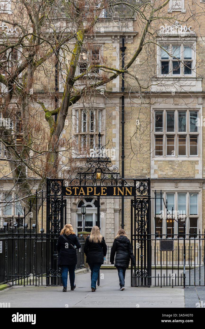 Les gens marchent à travers des portes en fer forgé pour arriver au Staple Inn près de High Holborn, Londres, Angleterre, Royaume-Uni Banque D'Images