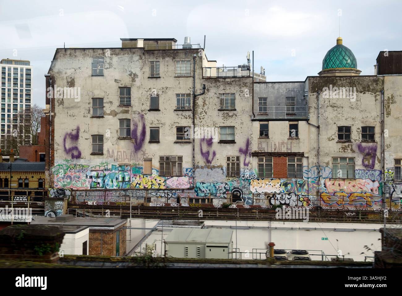 Vue depuis le train de chemin de fer de bâtiments délabrés et de graffitis dans le paysage urbain de Brixton février 2025 Londres Angleterre Royaume-Uni KATHY DEWITT Banque D'Images