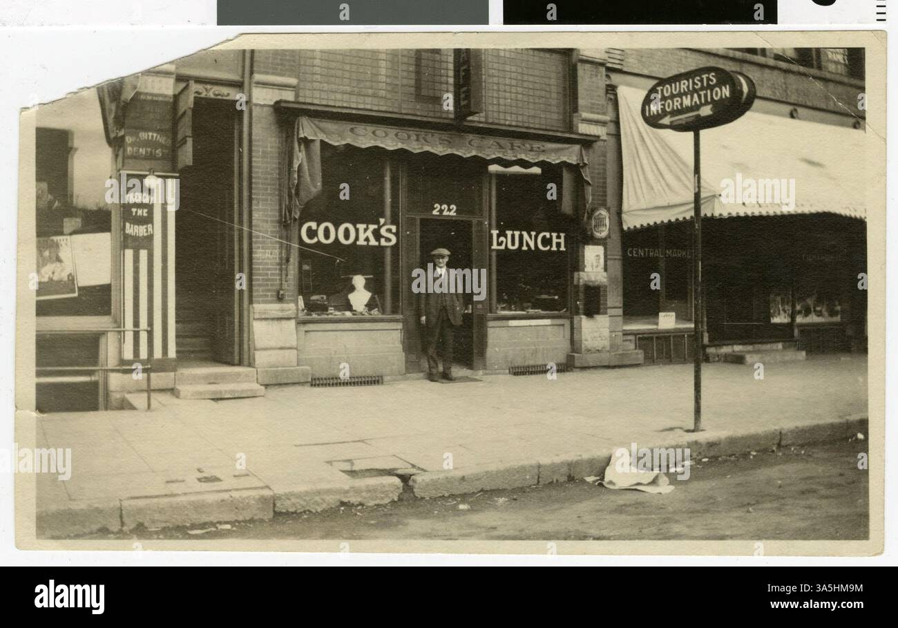 Cook's Cafe était situé au 222 South Minnesota Avenue dans le quartier de Peter. Cette photographie, prise en mai 1923, montre des panneaux pour Dr Bittner, un dentiste, et Frenchie le Barbier, avec un grand panneau d'information touristique pointant vers le café. Banque D'Images