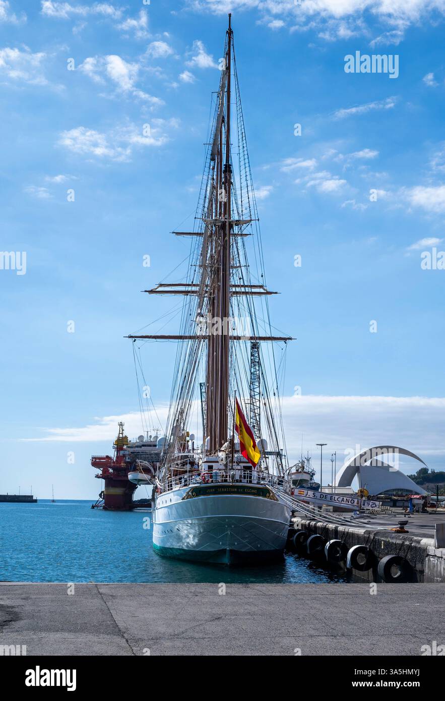 Un grand voilier est amarré à un quai. Le ciel est clair et bleu, et l'eau est calme Banque D'Images
