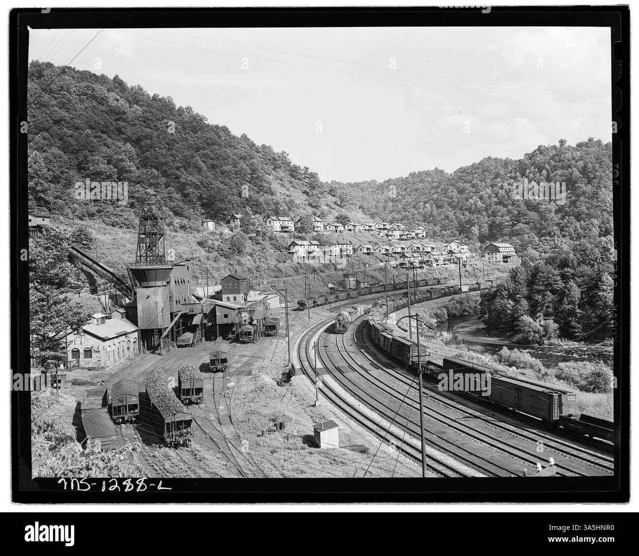 Cette image montre la bascule, les unités de logement et les wagons à charbon à New River Pocahontas Corp. Mine Cabels dans le comté de McDowell, Virginie-occidentale, représentant des éléments clés de l'infrastructure minière de charbon et des logements des travailleurs. Banque D'Images