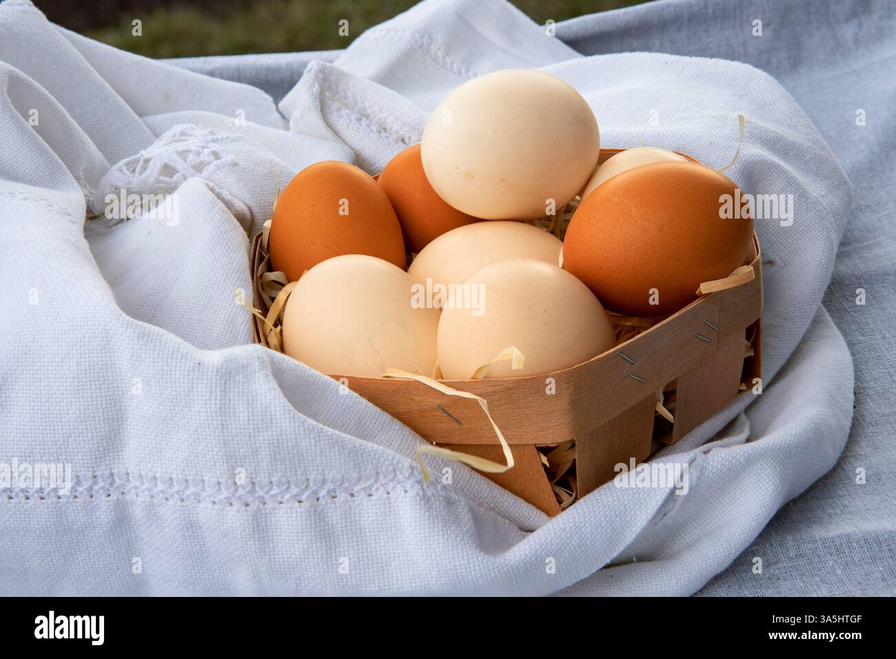 Oeufs de poule bruns frais disposés sur tissu de lin, produit agricole naturel, vue de dessus Banque D'Images